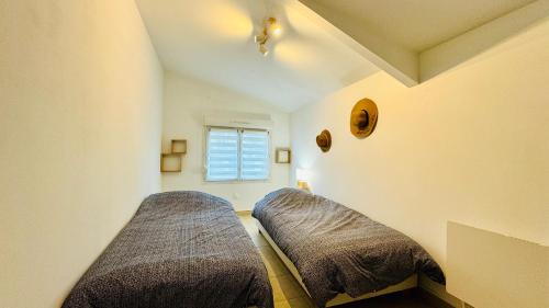 a bedroom with two beds and a window at La scintillante au coeur de Merlimont Plage in Merlimont