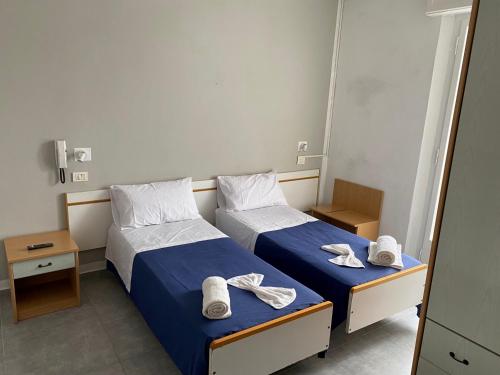 HOTEL PICCARI Nuova gestione في ريميني: سريرين في غرفة الفندق عليها مناشف