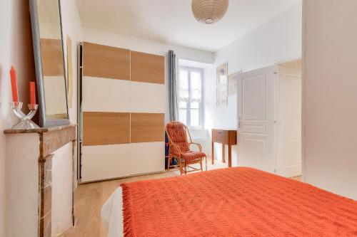 une chambre avec un lit, une chaise et un miroir dans l'établissement Escapade à 150m de la plage des Sables d'Olonne, à Les Sables-dʼOlonne