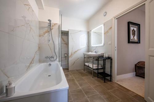 łazienka z wanną i umywalką w obiekcie Hôtel de la Poste w mieście Avallon