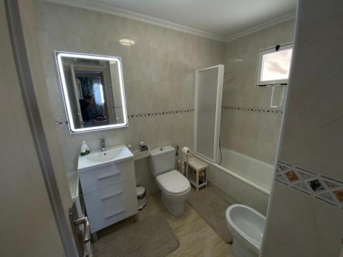 bagno con servizi igienici, lavandino e specchio di Pino Parquemar a La Mata