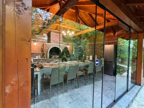 a glass extension of a house with a table and chairs at Pintea Chalet in Baia-Sprie