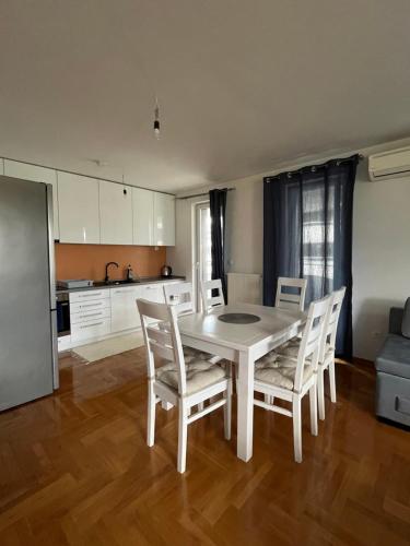 een witte eettafel en stoelen in een keuken bij Waves Apartment 106 in Sarajevo