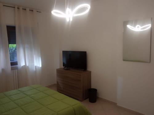 - une chambre avec un lit et une télévision sur une commode dans l'établissement 4 Seasons b&b, à Potenza