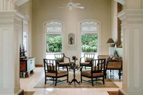 - une salle à manger avec des chaises, une table et des fenêtres dans l'établissement Maniumpathy Hotel, à Colombo