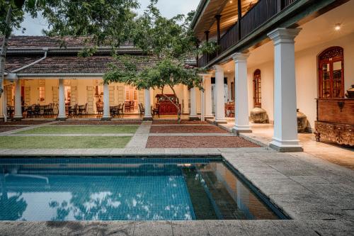 an estate with a swimming pool in front of a house at Maniumpathy Hotel in Colombo