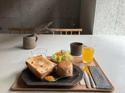 talerz jedzenia z tostem i szklankę soku pomarańczowego w obiekcie Gunjo no Tsuki w mieście Kanazawa