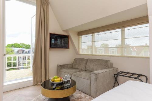 a living room with a couch and a table at Novallure Villa Margaretha - Short Stay Apartments in Rijswijk