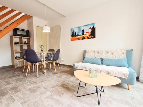 uma sala de estar com um sofá e uma mesa em La perle du Roussillon em Fitou