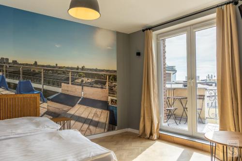 a room with a bed and a balcony with a view at Flamingo Centrum in Łódź