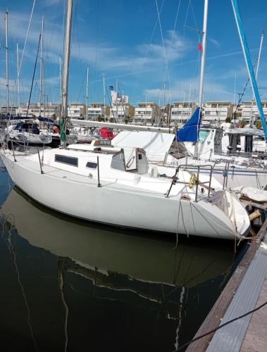 a white boat is docked in a harbor at Veleiro Cozy Vintage in Lisbon