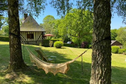 een hangmat tussen twee bomen in een tuin bij Charming Normandy House in Fort-Moville