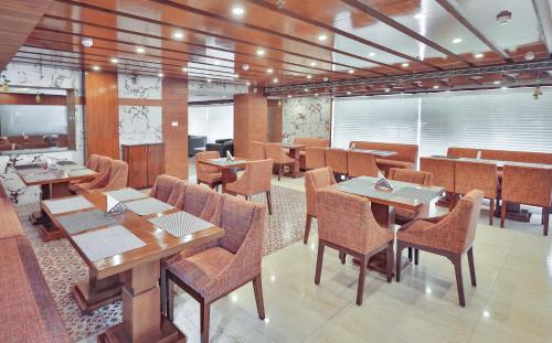 a dining room with wooden tables and chairs at Hotel Cama in Chandīgarh