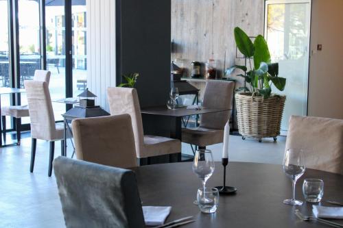 a restaurant with a table with wine glasses on it at The Originals Boutique, Hôtel Neptune, Montpellier Sud in Carnon-Plage