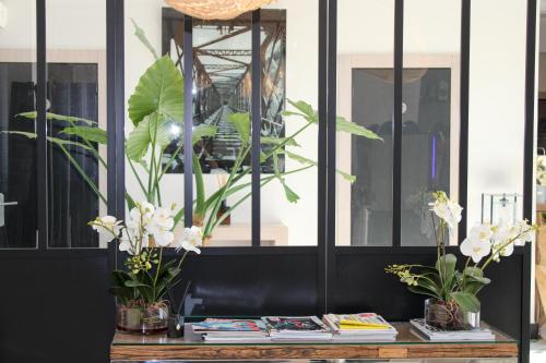 a table with potted plants on top of it at The Originals Boutique, Hôtel Neptune, Montpellier Sud in Carnon-Plage
