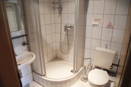 uma casa de banho com um chuveiro, um WC e um lavatório. em Hotel Zur Krone em Lorch am Rhein