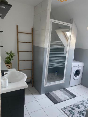 a bathroom with a sink and a washing machine at Maison calme et fonctionnelle business sportifs et familles PAS DE FETE in Corbeil-Essonnes