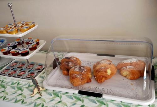 un contenitore di plastica con croissant e pasticcini su un tavolo di Bellatmosfera a Trani