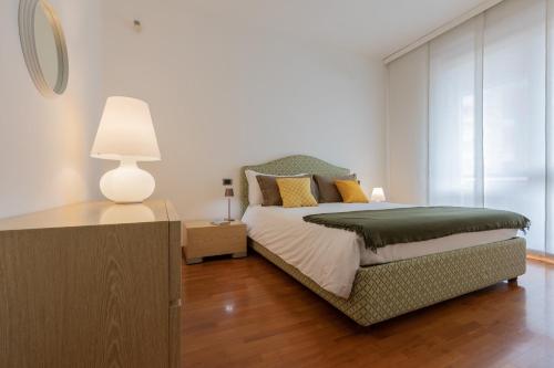 a bedroom with a bed and a table with a lamp at Villetta con Giardino allo Stadio by Wonderful Italy in Turin