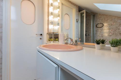 a bathroom with a pink sink and a mirror at Villetta con Giardino allo Stadio by Wonderful Italy in Turin