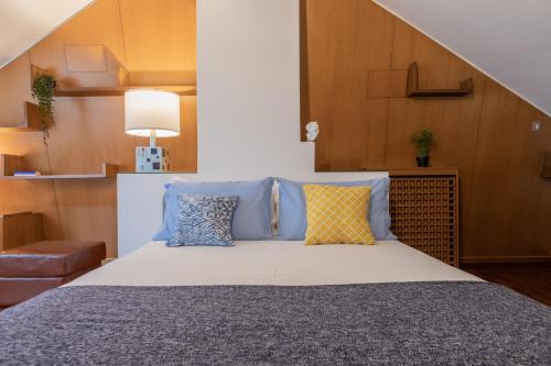 a bedroom with a bed with blue and yellow pillows at Villetta con Giardino allo Stadio by Wonderful Italy in Turin