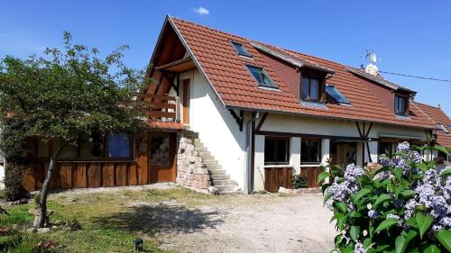 une maison avec un toit rouge et quelques fleurs dans l'établissement chez martine, à Stotzheim