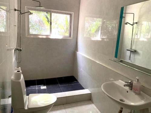 a bathroom with a sink and a toilet and a window at HomeVilla in Brusubi