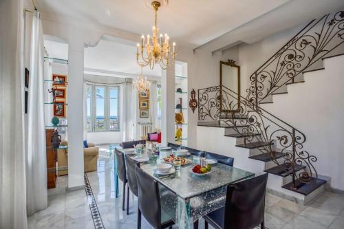 une salle à manger avec une table et des chaises et un escalier dans l'établissement #15 Sea front Villa AC stunning view for 6 pers wifi, à Nice