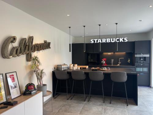 une cuisine avec un comptoir et des tabourets. dans l'établissement Colmar Appartement terrasse 10min centre ville, à Widensolen