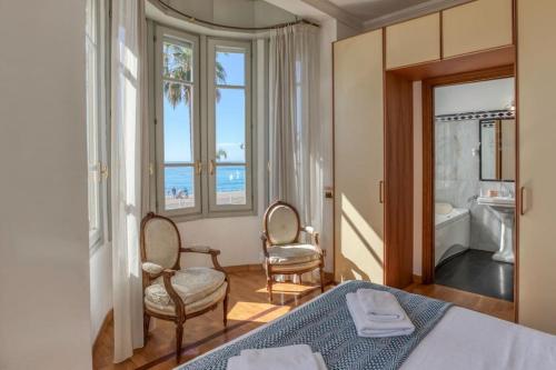 - une chambre avec un lit et deux chaises et une salle de bains dans l'établissement #15 Sea front Villa AC stunning view for 6 pers wifi, à Nice