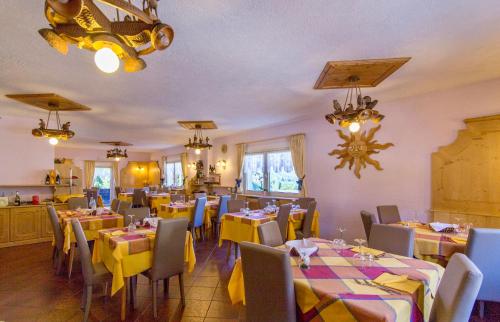 ein Esszimmer mit Tischen und Stühlen sowie gelben Tischdecken in der Unterkunft Hotel Siera Hof in Sappada