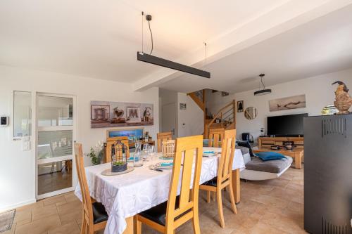 une salle à manger et un salon avec une table et des chaises dans l'établissement Belle maison de vacances, à Belz