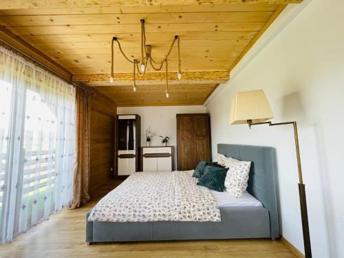 a bedroom with a bed and a wooden ceiling at Apartamenty u Ptaszka in Zakopane