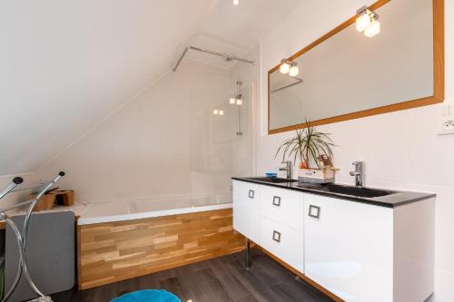 une salle de bains avec lavabo et baignoire dans l'établissement Belle maison de vacances, à Belz
