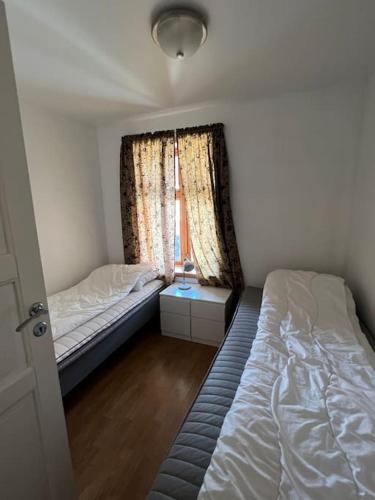 a small bedroom with two beds and a window at Fishermans Apartment A13 in Nautnes