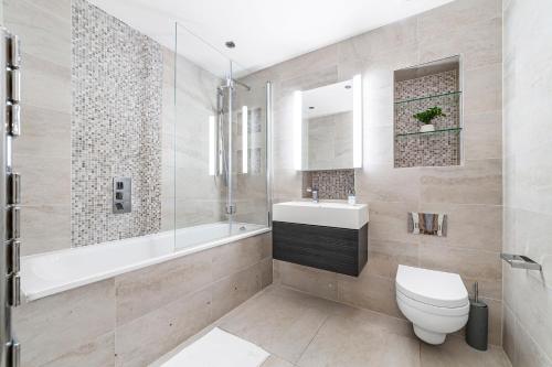 The Hoxton Collection في لندن: حمام مع مرحاض ومغسلة وحوض استحمام