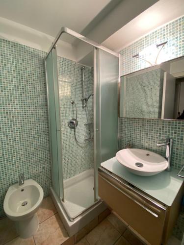 une salle de bain avec un lavabo, une douche et des toilettes dans l'établissement Appartement vue mer, à Villefranche-sur-Mer