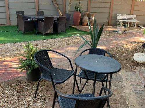 dos sillas y una mesa y una mesa y sillas en Self-Catering Garden Flat in Hochlandpark - 5min from Widhdoek CBD, en Windhoek
