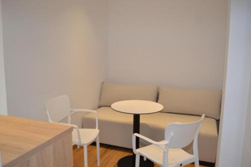 Zimmer mit einem Tisch, Stühlen und einem Sofa in der Unterkunft GL Hotel Ksamil in Ksamil