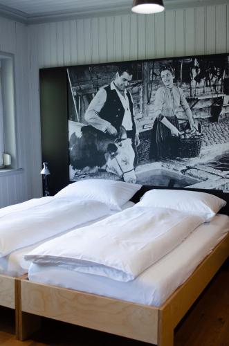 a bedroom with two beds with a picture on the wall at Concept Hotel Landhaus - Digital Hotel in Burgdorf