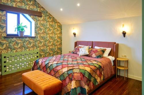 - une chambre avec un lit doté d'une couette colorée et d'une fenêtre dans l'établissement Villa Vermont Qusar, à Qusar