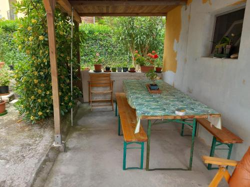 una mesa verde y un banco en una habitación con plantas en Casa Travaglini en Fano
