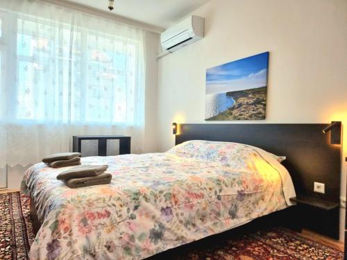 a bedroom with a bed and a large window at Comfortable Family Apartment with Parking in Burgas