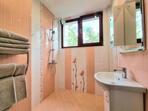 a bathroom with a sink and a window at Comfortable Family Apartment with Parking in Burgas