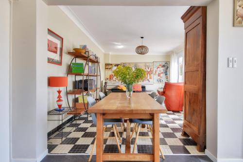 une salle à manger avec une table en bois et un sol en damier dans l'établissement 800m de la plage - Maison 4 adultes - 4 enfants, à Barbâtre