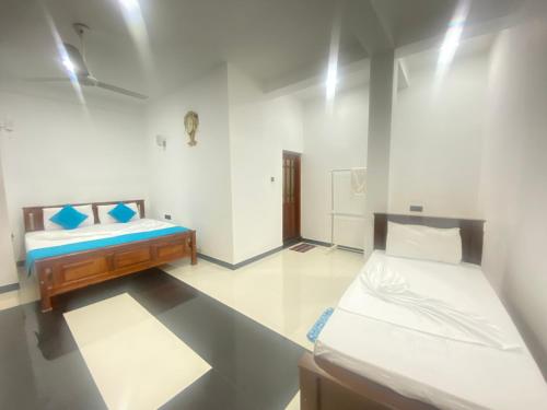 a room with two beds in a room at La Maison Yala in Tissamaharama