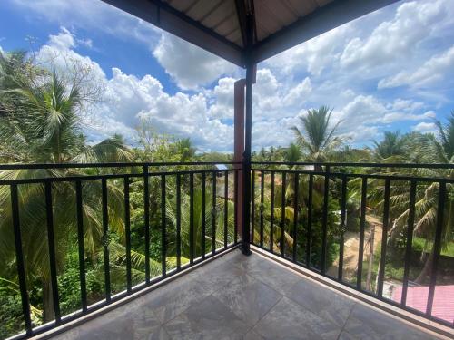 a view from the balcony of a resort with palm trees at La Maison Yala in Tissamaharama