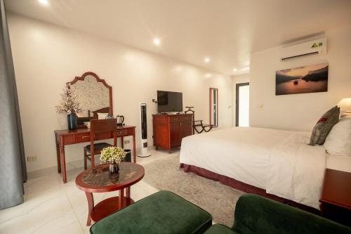 Bak KanにあるNhà hàng - Khách sạn Sơn Nữのベッドとデスクが備わるホテルルームです。