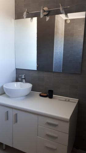 une salle de bain avec un lavabo blanc et un miroir dans l'établissement Appartement dans maison, à Saint-Étienne-le-Laus