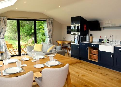 a kitchen and living room with a table and chairs at The Cabin at the Croft - Idyllic rural retreat perfect for couples and dogs in Leigh